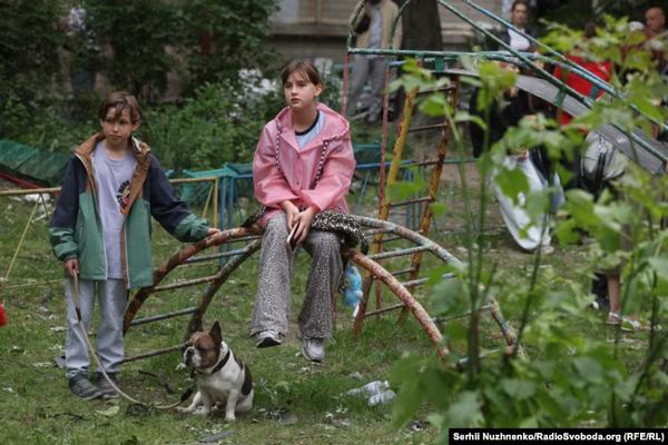 Діти спостерігають за деблокуванням тіл загиблих з-під завалів багатоповерхівки в Солом'янському районі Києва, 17 червня 2025 року