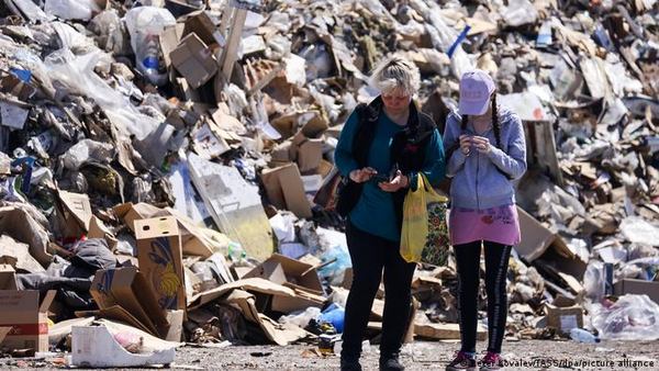 Маріупольці біля купи сміття 