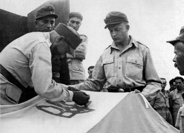 Підготування до урочистого підняття українського прапора у таборі для військовополонених дивізійників. Місто Ріміні, Італія, 25 травня 1946 року / Фото з архіву проєкту "Локальна історія"