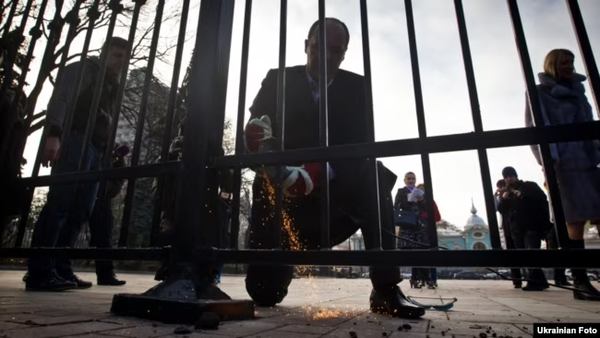 Депутат Верховної Ради Андрій Парубій розпилює паркан біля парламенту. Київ, 18 листопада 2011 року