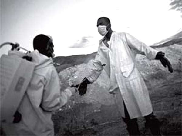 Гаитянские медики обрабатывают друг друга дезинфицирующим раствором после захоронения умерших от холеры в братской могиле на окраине Порт-о-Пренса. Эпидемия холеры на Гаити началась в октябре 2010 года — вскоре после катастрофического землетрясения, превратившего сотни тысяч людей в беженцев в собственных городах. Она уже привела к гибели нескольких тысяч человек  